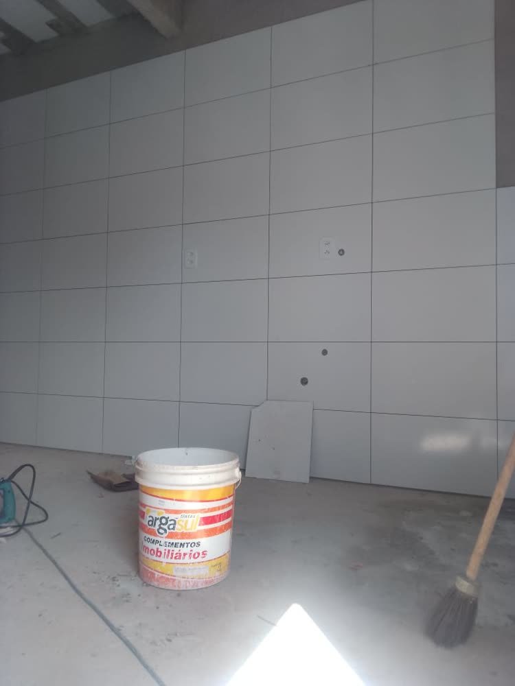 Parede revestida com placas cinza e pontos elétricos instalados